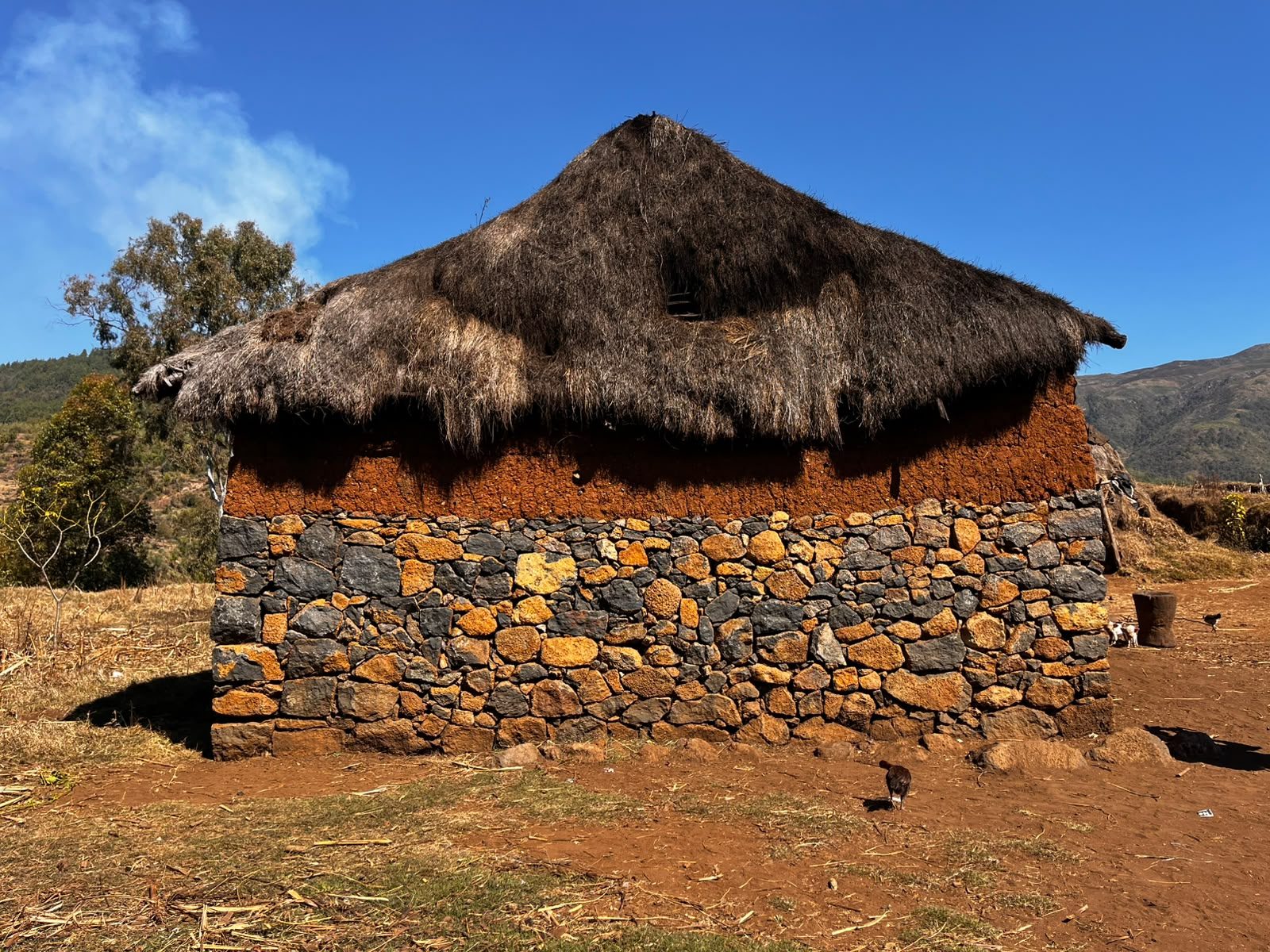 Traditional stone and earth house with a thatched roof